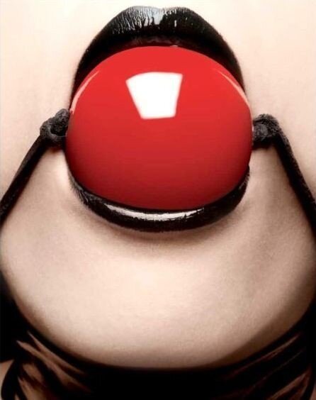 光沢のある黒い唇に完璧に座っている美しい赤いボールギャグ picture