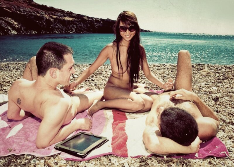 Hot brunette gives double handjob on the beach picture