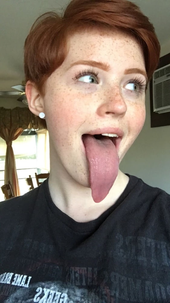 Cute redhead sticks out her huge tongue picture