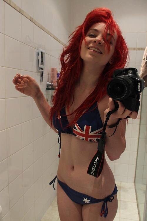 Kızıl saçlı aynanın önünde bikiniyle fotoğraf çekiyor. picture