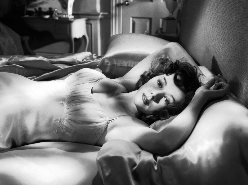 PIC - Gloria Grahame reclining on a bed. picture
