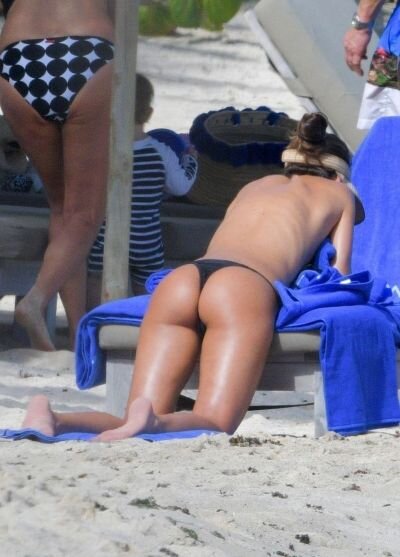 Izabel Goulart topless tanning at the beach covering her nude boobs with a towel showing off her sexy ass in a thong bikini. picture