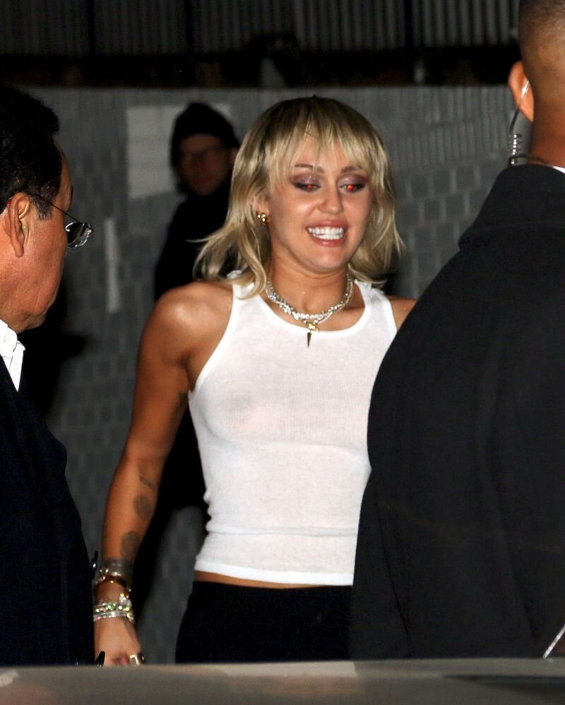 Miley Cyrus braless boobs in a white tank top showing off her tits seen by paparazzi. picture