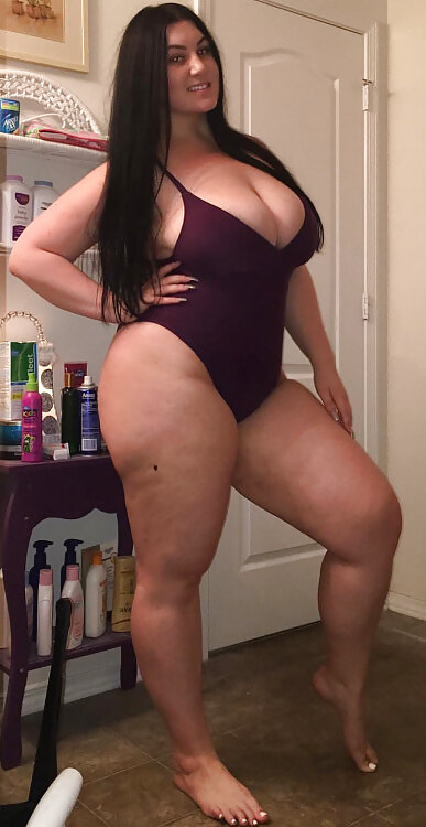 Plump Busty Amateur busting out of her tight purple one piece bikini picture