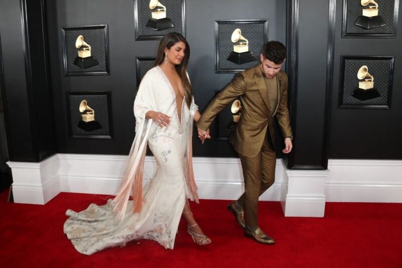 Priyanka Chopra braless boobs showing nice cleavage with her big tits in a very low cut revealing dress arriving to the Grammy Awards with N picture