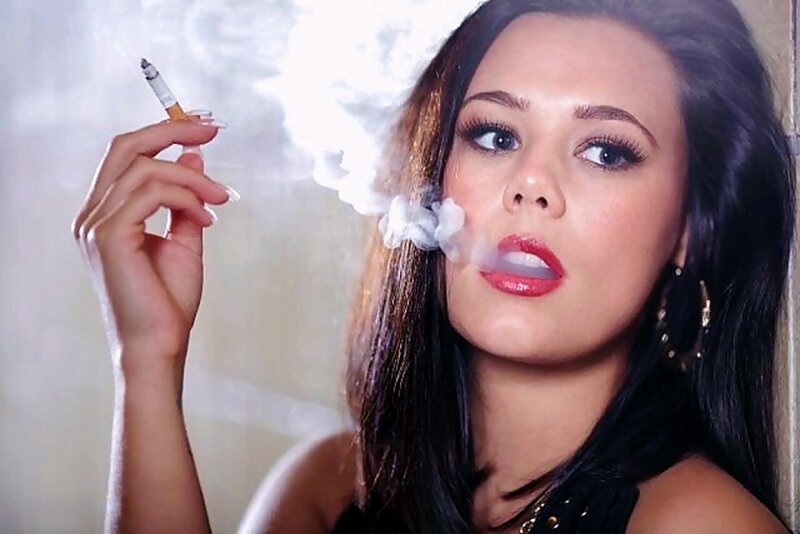 Gorgeous, blue eyed brunette with ruby red lips exhaling her cigarette smoke picture
